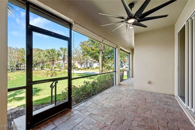 unfurnished sunroom with a ceiling fan