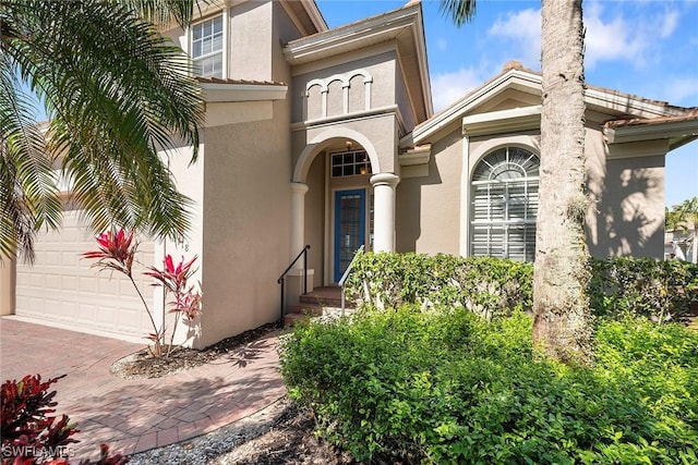 property entrance featuring stucco siding and decorative driveway