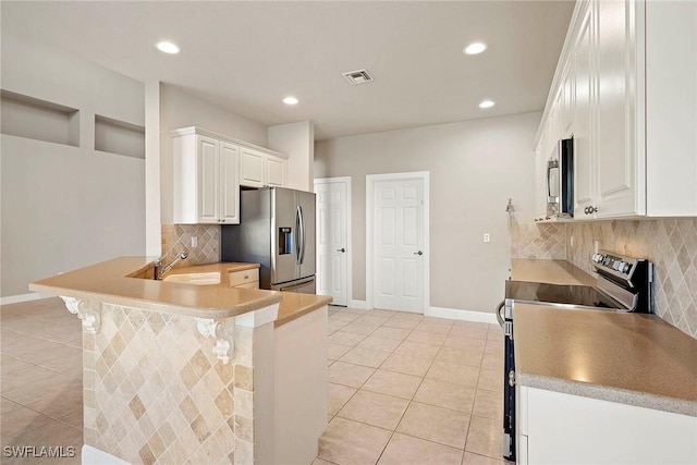 kitchen featuring visible vents, a kitchen breakfast bar, stainless steel appliances, a peninsula, and light tile patterned floors