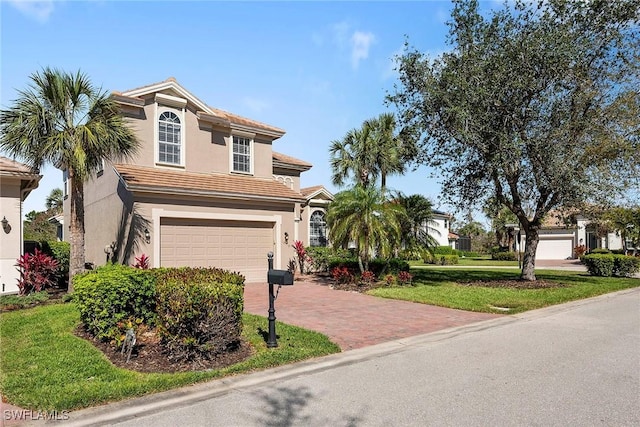 view of front of property with a tiled roof, decorative driveway, a garage, and stucco siding