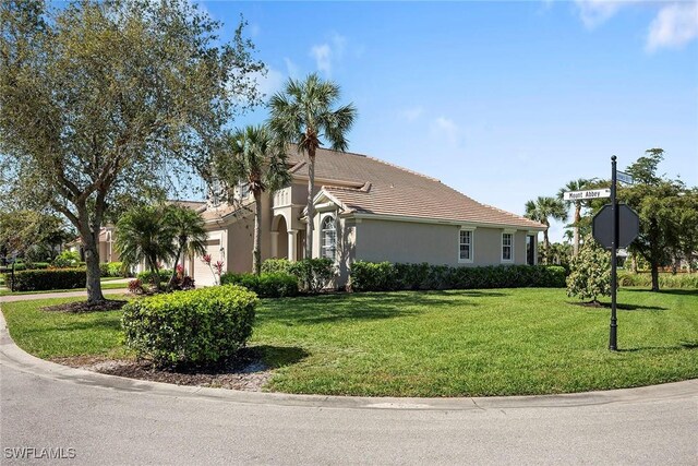 view of front facade featuring stucco siding, a front lawn, and a garage