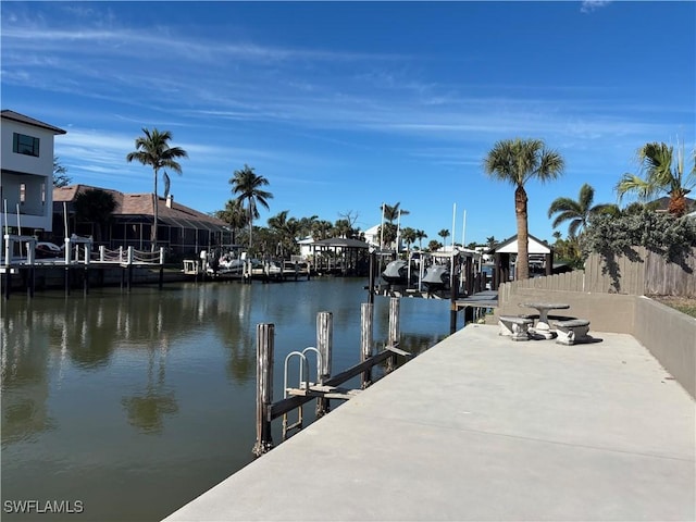 view of dock featuring fence and a water view