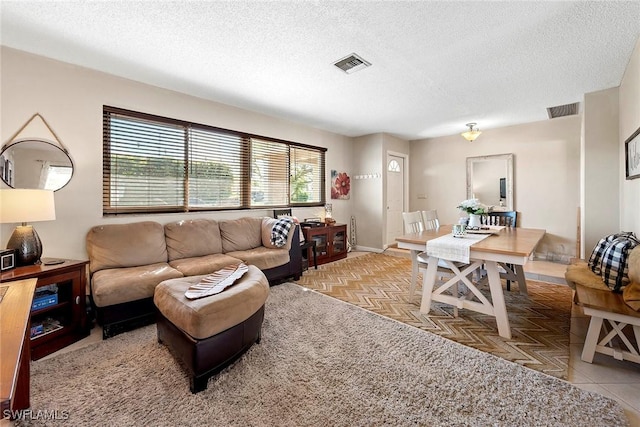 living room featuring visible vents and a textured ceiling