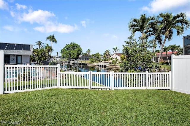 view of yard featuring fence, a boat dock, a swimming pool, a water view, and a residential view