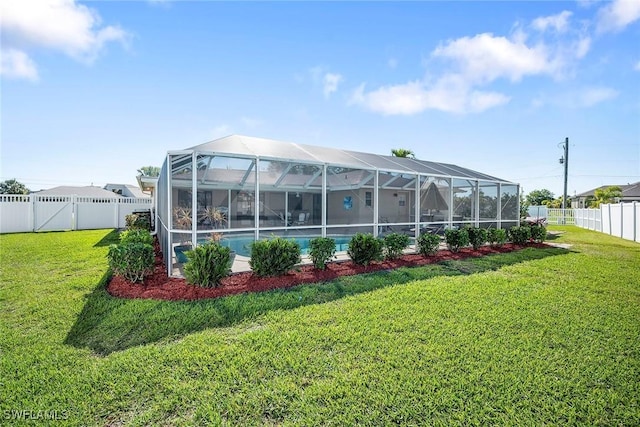 back of house featuring a yard, a fenced in pool, a fenced backyard, and glass enclosure