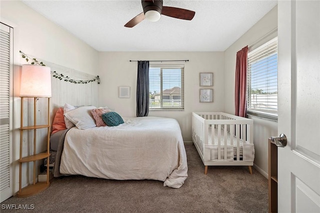 carpeted bedroom with multiple windows and a ceiling fan