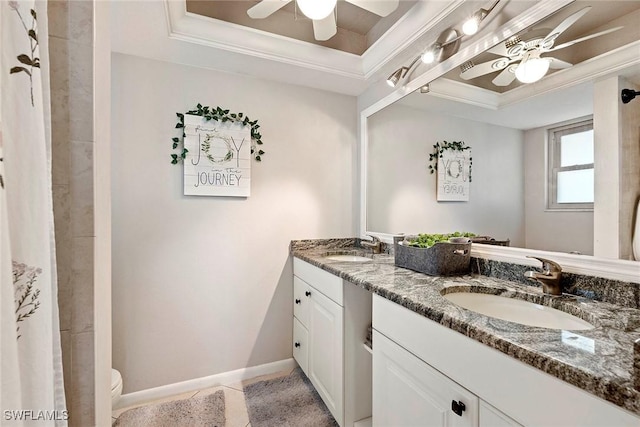 bathroom featuring a sink, a tray ceiling, ornamental molding, and ceiling fan