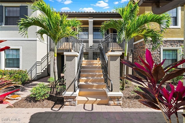 entrance to property with covered porch and stucco siding