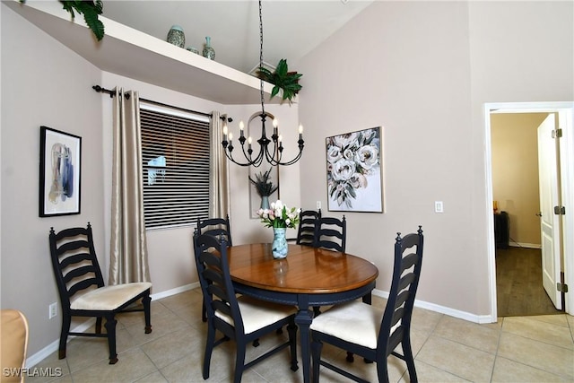 dining space featuring light tile patterned floors, a chandelier, baseboards, and vaulted ceiling