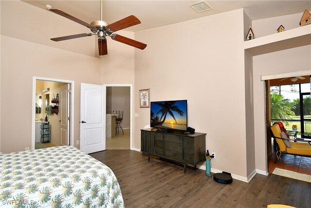 bedroom with visible vents, baseboards, a high ceiling, and dark wood-style flooring