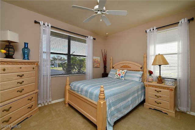 bedroom featuring light colored carpet, baseboards, and ceiling fan