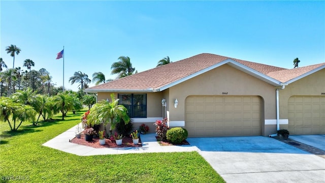 single story home featuring a garage, stucco siding, driveway, and a front yard