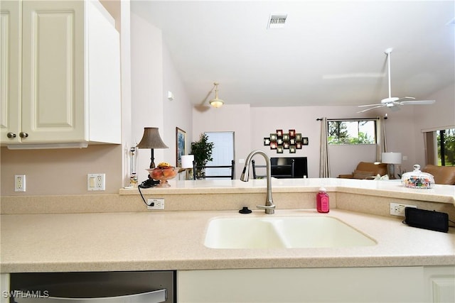 kitchen featuring visible vents, a sink, open floor plan, dishwashing machine, and vaulted ceiling