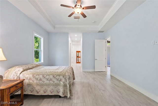 bedroom featuring visible vents, a raised ceiling, and crown molding