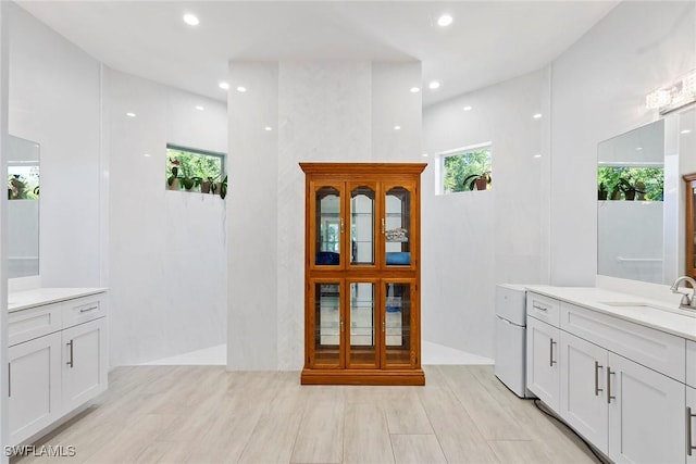 full bathroom featuring recessed lighting, vanity, and walk in shower