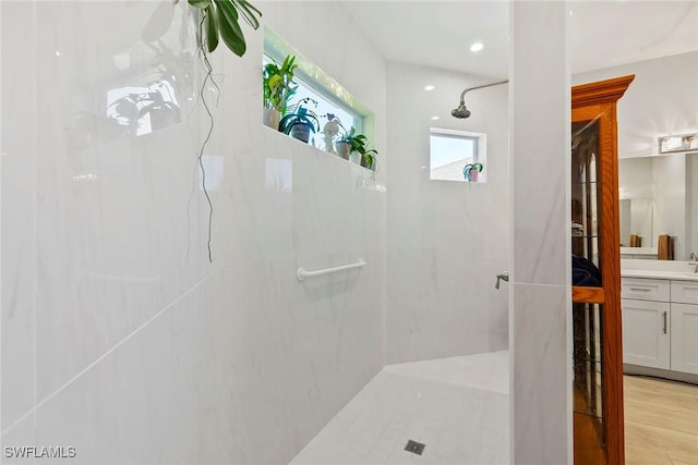 bathroom with vanity, wood finished floors, and a walk in shower