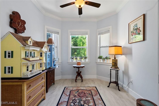 sitting room featuring light wood finished floors, ceiling fan, baseboards, and ornamental molding