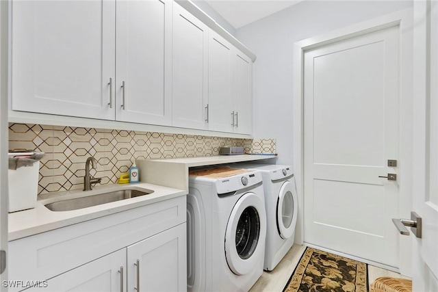 washroom featuring cabinet space, separate washer and dryer, and a sink