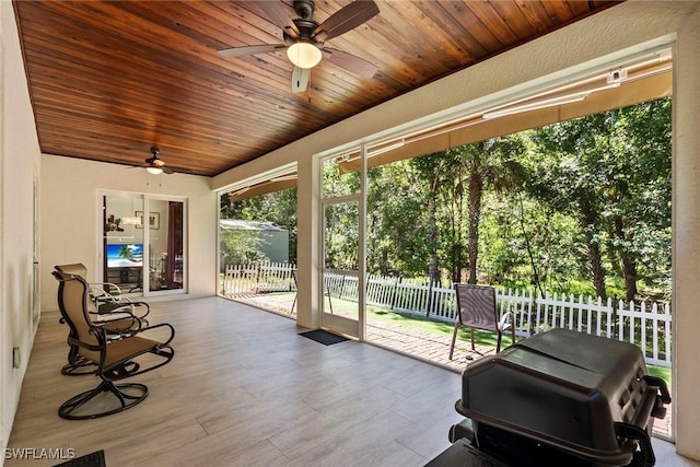 sunroom / solarium with wooden ceiling and a ceiling fan