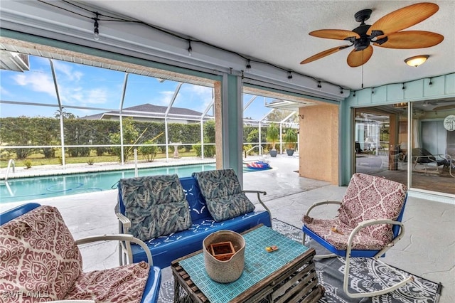 view of patio featuring glass enclosure, an outdoor pool, and ceiling fan