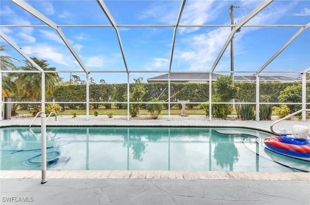 pool with glass enclosure and a patio