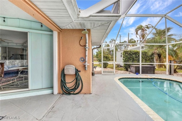 view of swimming pool featuring glass enclosure and a patio