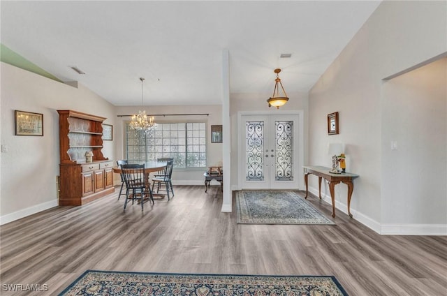 entrance foyer with french doors, baseboards, wood finished floors, and vaulted ceiling