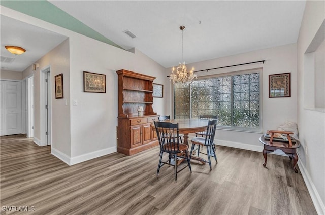 dining room with vaulted ceiling, light wood-style floors, baseboards, and a chandelier