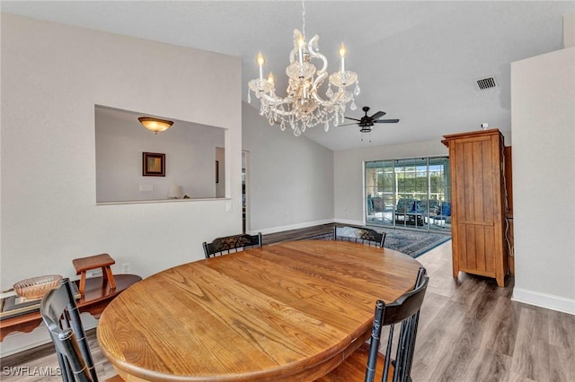 dining room featuring visible vents, high vaulted ceiling, ceiling fan with notable chandelier, wood finished floors, and baseboards