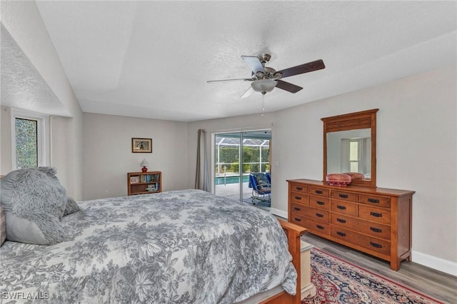 bedroom featuring a ceiling fan, access to outside, a textured ceiling, wood finished floors, and baseboards