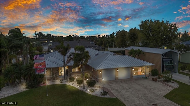 view of front of property featuring driveway, metal roof, and a garage