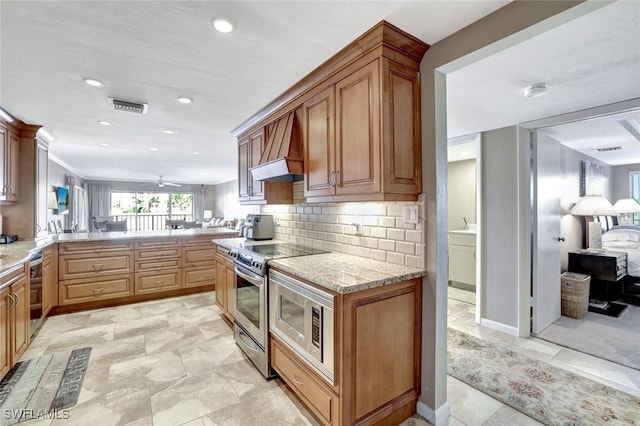 kitchen featuring tasteful backsplash, visible vents, custom range hood, a peninsula, and stainless steel appliances