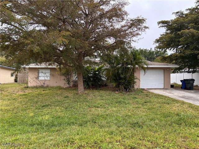 view of front of home with fence, a front yard, stucco siding, a garage, and driveway