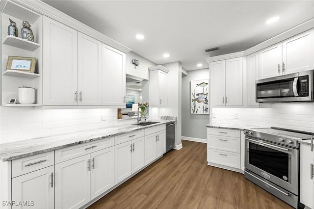 kitchen with open shelves, dark wood finished floors, white cabinets, stainless steel appliances, and a sink