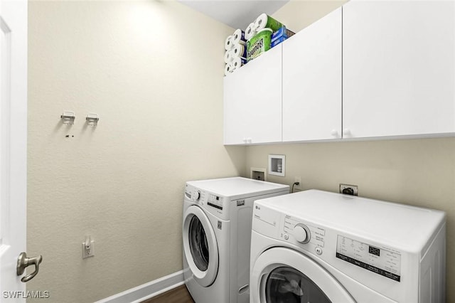 washroom featuring dark wood finished floors, separate washer and dryer, cabinet space, and baseboards