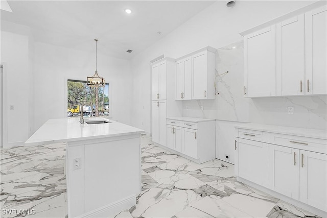kitchen featuring recessed lighting, a sink, light countertops, white cabinetry, and marble finish floor