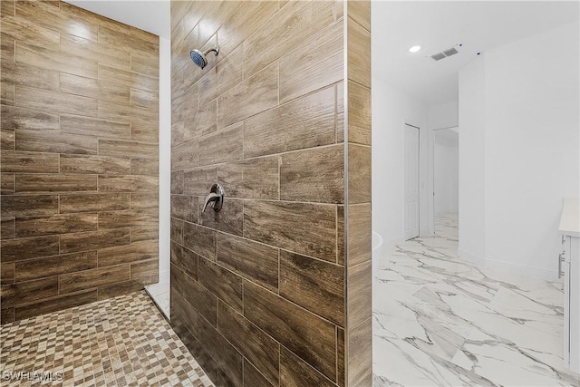 full bathroom featuring visible vents, marble finish floor, tiled shower, and baseboards