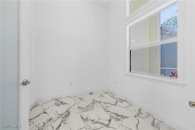 empty room featuring baseboards and marble finish floor