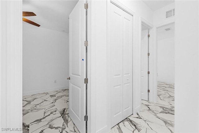 hallway featuring visible vents, baseboards, and marble finish floor