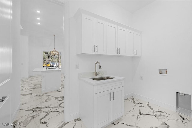 laundry area featuring marble finish floor, a sink, cabinet space, baseboards, and hookup for a washing machine
