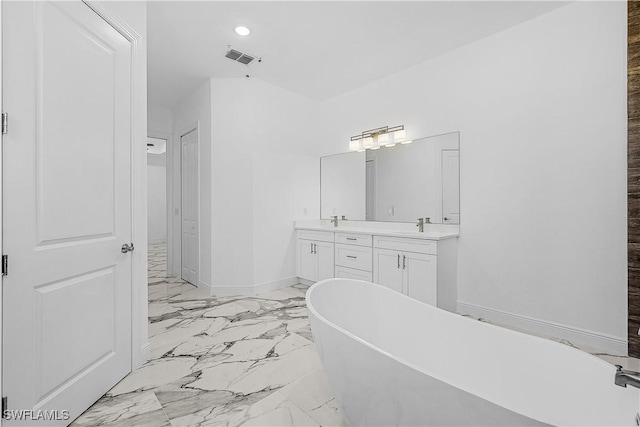 bathroom featuring visible vents, baseboards, double vanity, a soaking tub, and marble finish floor