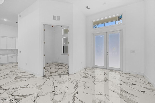 entryway featuring visible vents, a high ceiling, and french doors
