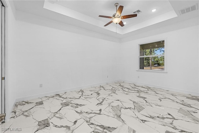 empty room featuring visible vents, recessed lighting, baseboards, and a tray ceiling