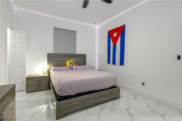 bedroom featuring marble finish floor and baseboards