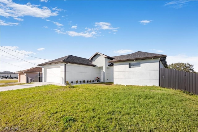 view of front of home with stucco siding, a front lawn, fence, concrete driveway, and an attached garage