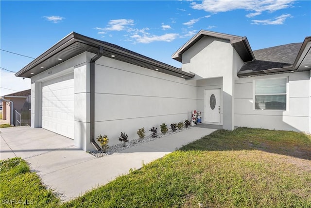 view of side of property with concrete driveway, a yard, a garage, and stucco siding