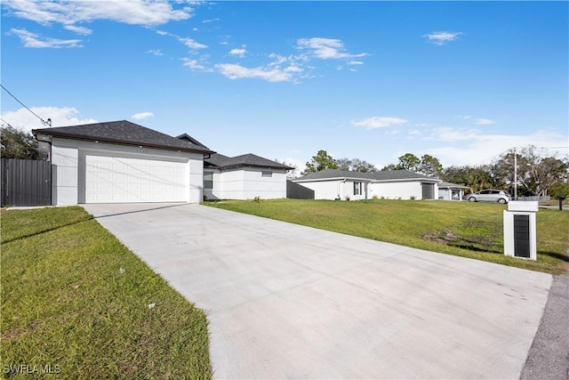 view of front of house with stucco siding, driveway, a front lawn, fence, and a garage