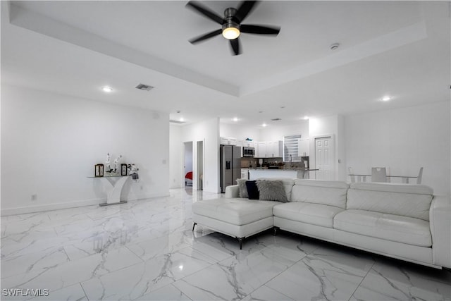 living room featuring visible vents, recessed lighting, a tray ceiling, and ceiling fan