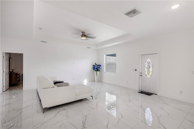 living area with visible vents, marble finish floor, a tray ceiling, recessed lighting, and ceiling fan