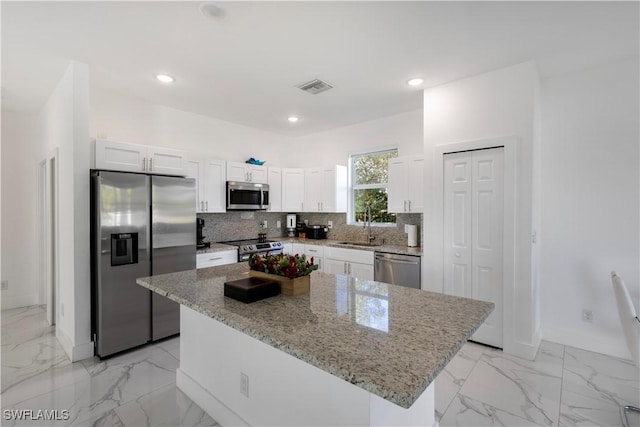 kitchen featuring visible vents, marble finish floor, a sink, appliances with stainless steel finishes, and decorative backsplash